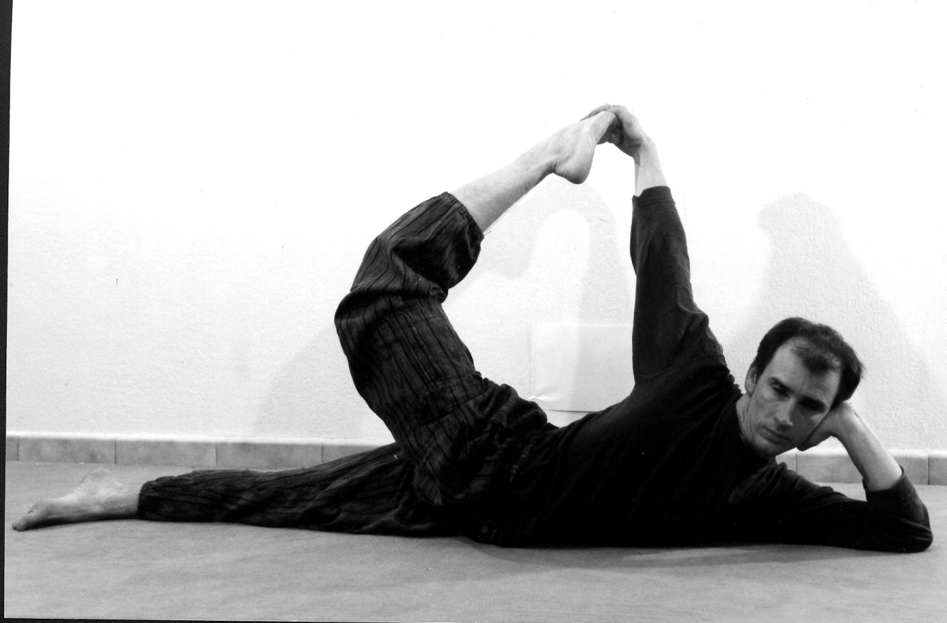 Ardha Dhanurâsana : allongé sur le côté, la tête posée dans une main, l’autre main saisit le pied de la jambe repliée en arrière.